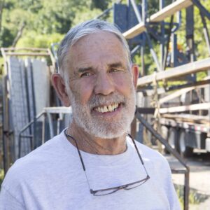 An older man smiles at the camera.