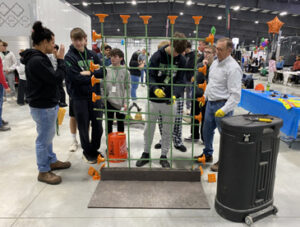 Students working, at the Lorain County Career Pathways Expo, on tying rebar used in poured concrete walls with the Modern Poured Walls team looking on and assisting.