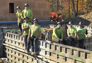 Miembros del equipo de Thompson Concrete posando para una foto sobre la estructura del edificio ya terminada.