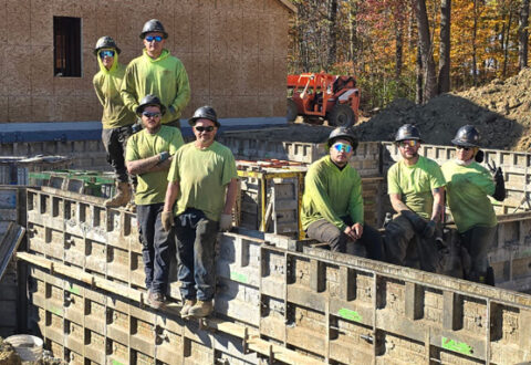 Miembros del equipo de Thompson Concrete posando para una foto sobre la estructura del edificio ya terminada.