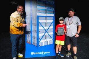 Three people pose with a large Western Forms cardboard display and an award plaque.