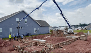Wide shot of residential construction project with a tall crane and construction workers.