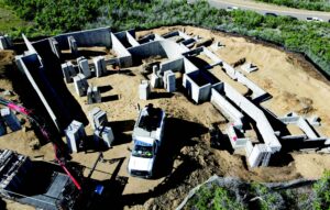 Aerial view of a concrete foundation with many curving hallways, and a white construction truck in the center.