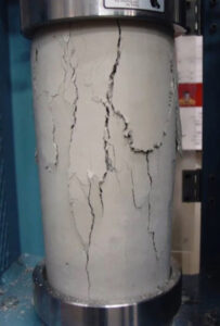 A cylinder of concrete with cracks in it.