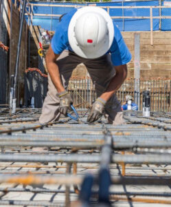 A construction worker lays rebar