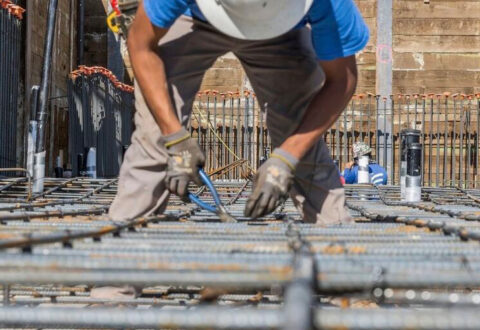 A construction worker lays rebar