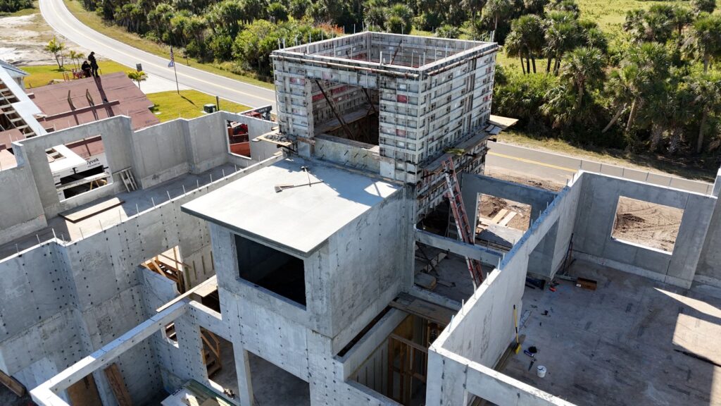 Mid-construction multi-level building with concrete foundations and walls poured.