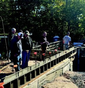 People stand above wooden frames in a construction site.