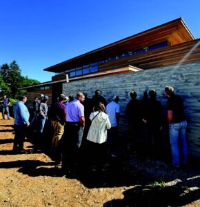 A group of people gather around a concrete wall.