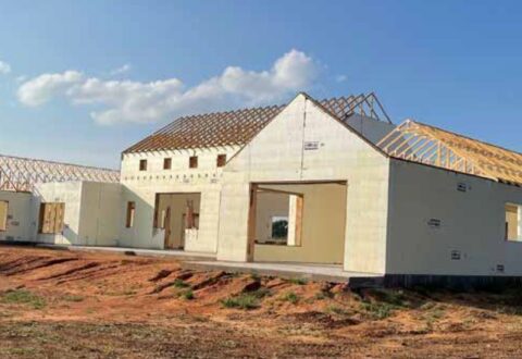 Concrete house in middle of field in building process